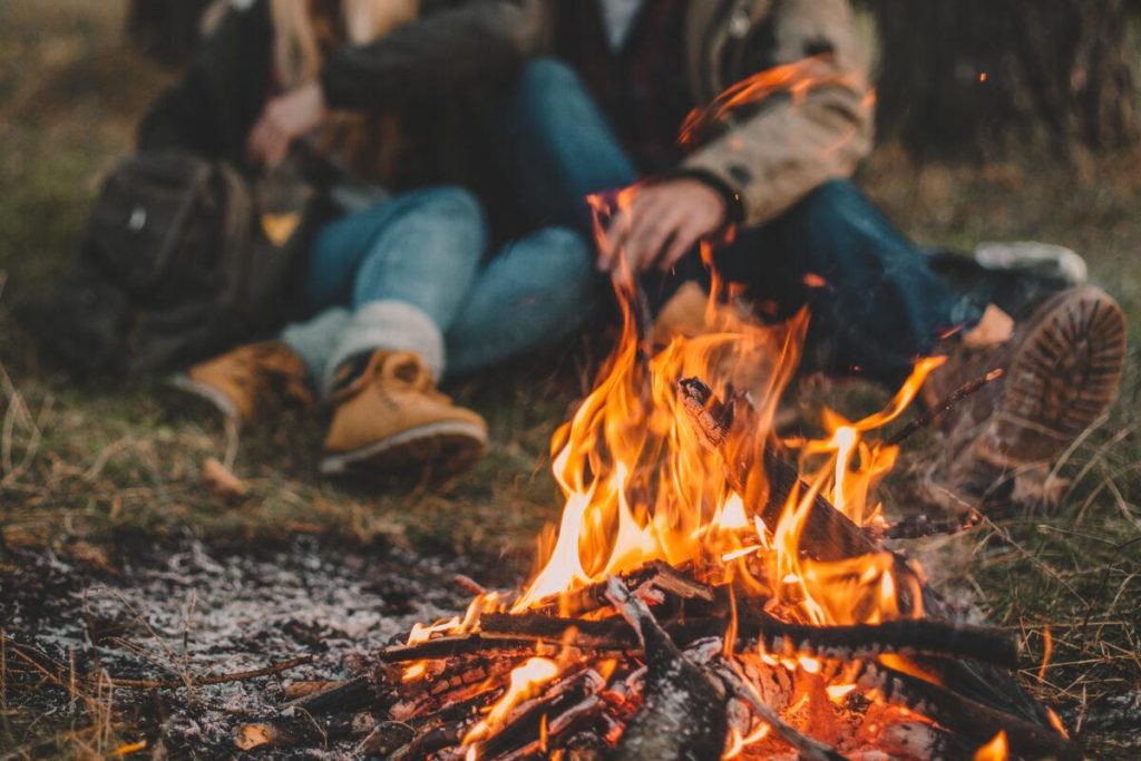 Traveler couple camping in the forest and relaxing near campfire